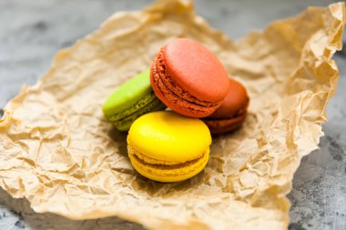 Birkaç taze renkli geleneksel Fransız acıbadem kurabiyesi pasta kurabiye kahverengi kağıt parşömen arka plan üzerinde Grup, yakın çekim