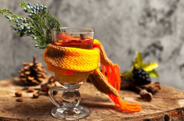 Sıcak içecek narenciye, applem meyveleri ve baharatlar ile üzerinde ahşap güdük seçici odak üzerinde dumanı tüten mulled şarap