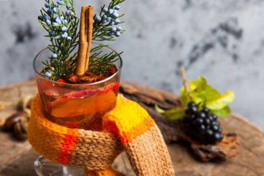 Sıcak içecek narenciye, applem meyveleri ve baharatlar ile üzerinde ahşap güdük seçici odak üzerinde dumanı tüten mulled şarap