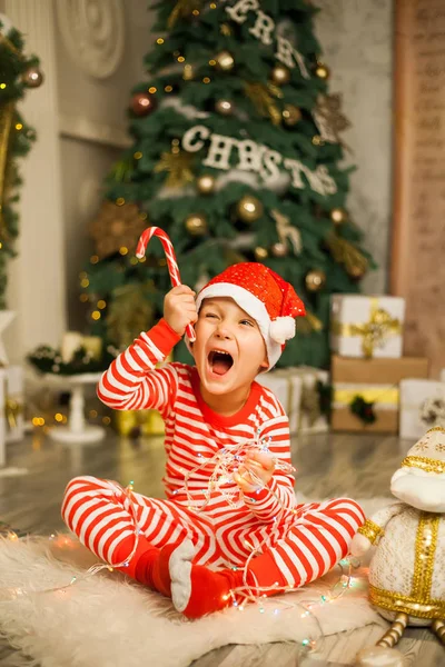 Lindo Niño Pijama Rojo Rayado Sombrero Encuentra Cerca Árbol Navidad —  Fotos de Stock