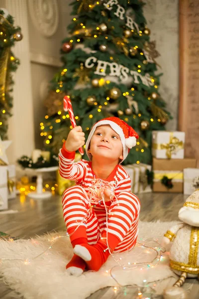 Cute Little Boy Striped Red Pajamas Hat Lies Christmas Tree — Stock Photo, Image