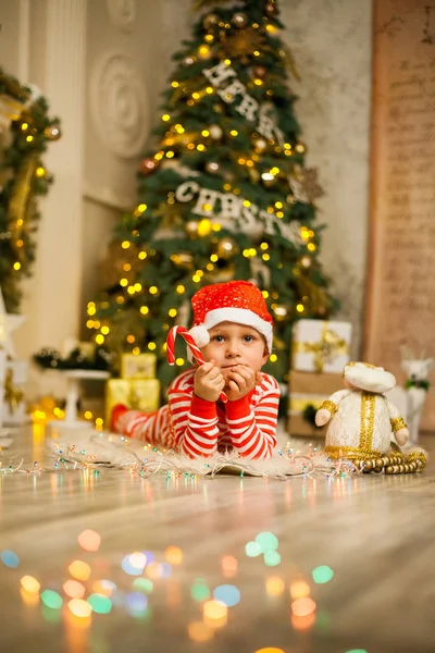 Lindo Niño Pijama Rojo Rayado Sombrero Encuentra Cerca Árbol Navidad —  Fotos de Stock