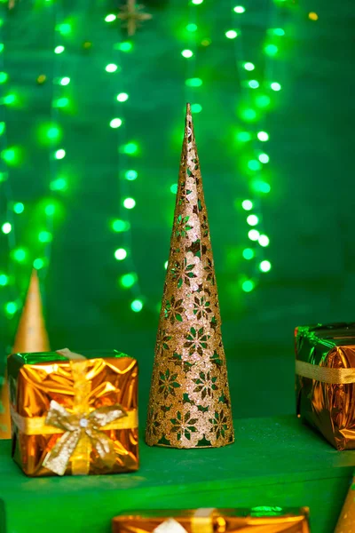 Christmas gift golden box on green background with led lights