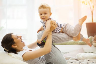 Genç anne bebeğini yatakta yatıyordu öpüşme