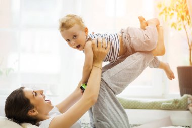 Genç anne bebeğini yatakta yatıyordu öpüşme