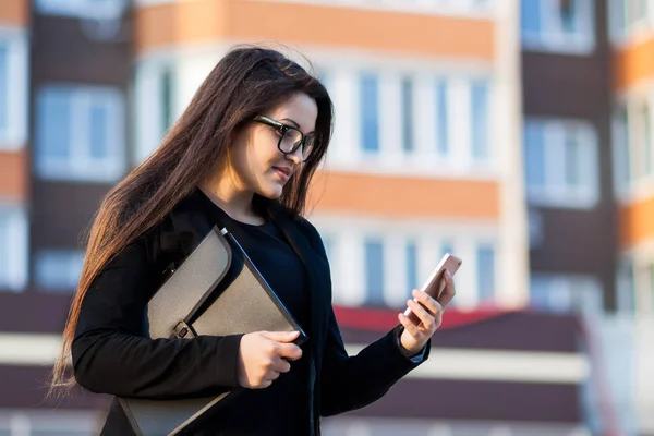 Успешная деловая женщина или предприниматель, пользующаяся мобильным телефоном во время прогулки на свежем воздухе. Работающая городская женщина — стоковое фото
