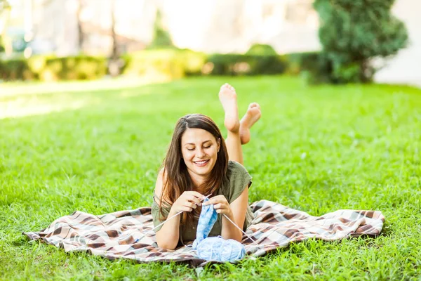 Mujer joven tejiendo al aire libre en el parque —  Fotos de Stock