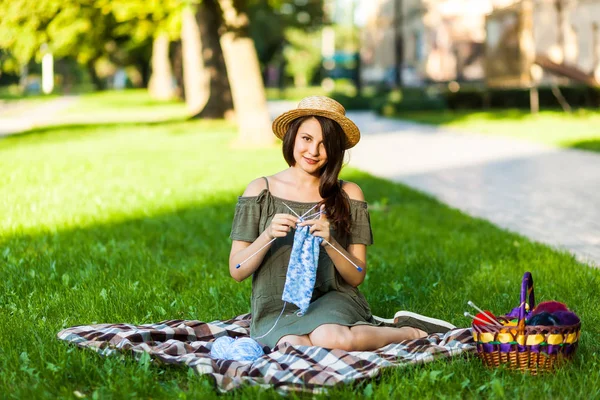 Mujer joven tejiendo al aire libre en el parque — Foto de Stock