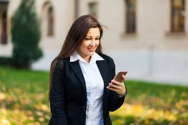 Успешная деловая женщина или предприниматель разговаривает по мобильному телефону во время прогулки на свежем воздухе. Работающая городская женщина — стоковое фото