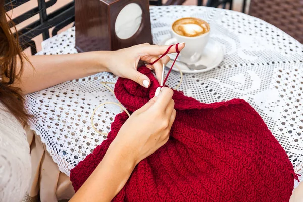 Молодая женщина вязание на террасе в кафе — стоковое фото