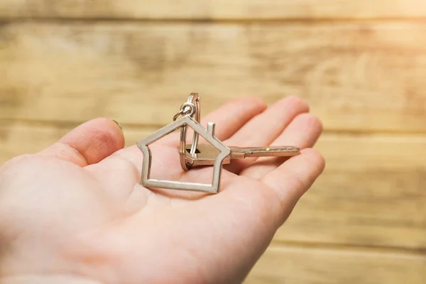 Hausschlüssel mit Hausfigur auf der Hand — Stockfoto