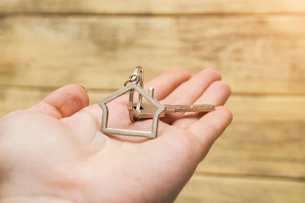 Llave de la casa con figura de la casa en la mano —  Fotos de Stock