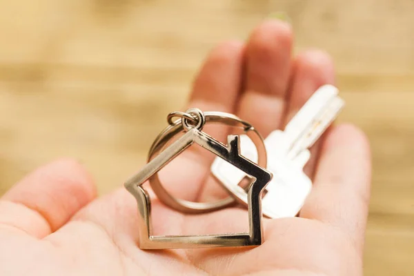 Ключ от дома с фигуркой на руке — стоковое фото