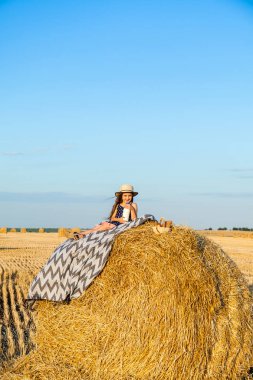 Gün batımında saman yığınları ile çavdar alanında Sevimli küçük çocuk.