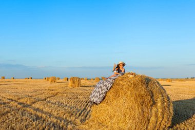 Gün batımında saman yığınları ile çavdar alanında Sevimli küçük çocuk.