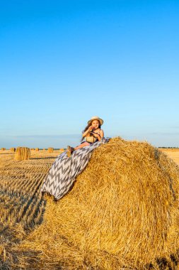 Gün batımında saman yığınları ile çavdar alanında Sevimli küçük çocuk.