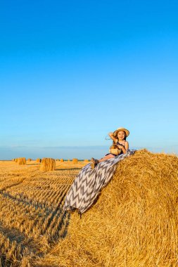 Gün batımında saman yığınları ile çavdar alanında Sevimli küçük çocuk.