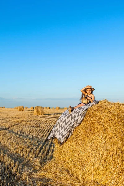Gün batımında saman yığınları ile çavdar alanında Sevimli küçük çocuk.