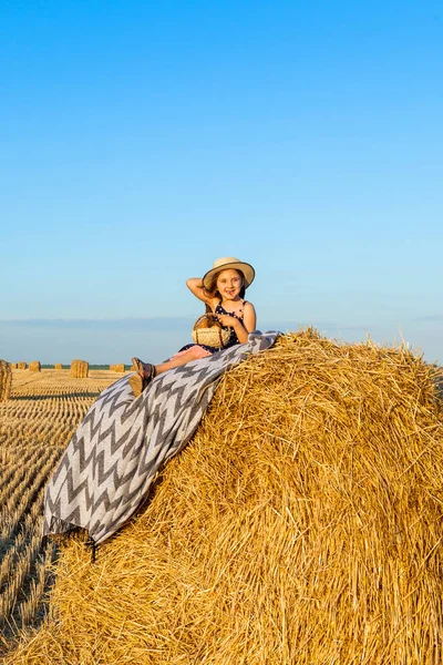 Roztomilé malé dítě v Žitném poli se seno na slunci. — Stock fotografie