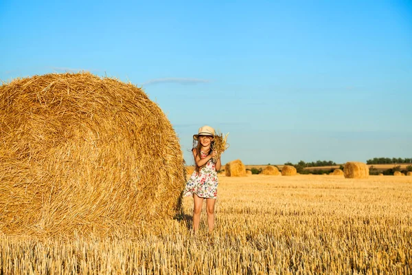 Rozkošné malé dítě v Žitném poli při západu slunce. — Stock fotografie