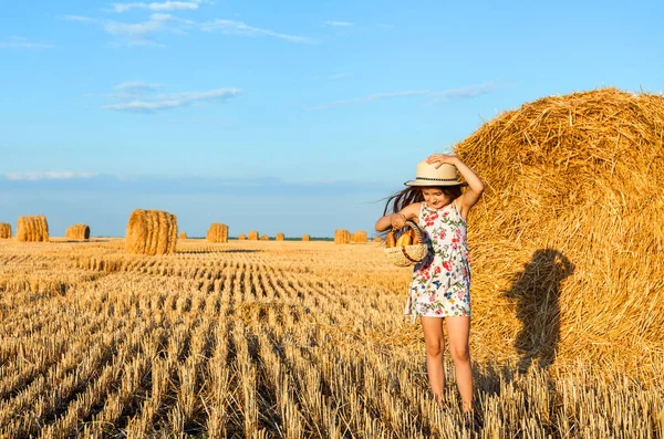 Красивая девушка на ржаном поле на закате с корзиной хлеба . — стоковое фото
