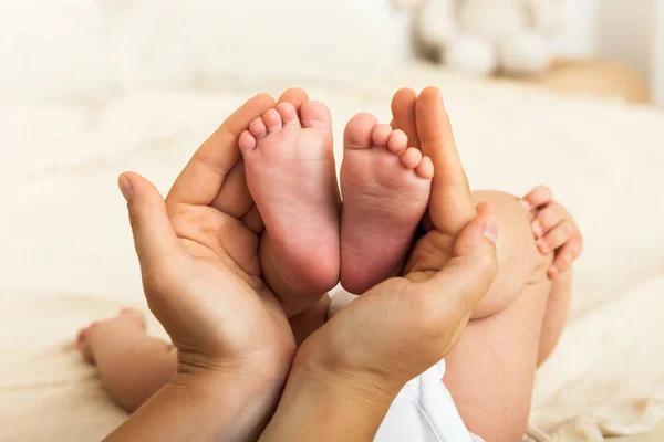 Pies de bebé en manos de madre. Mamá y su hijo . — Foto de Stock