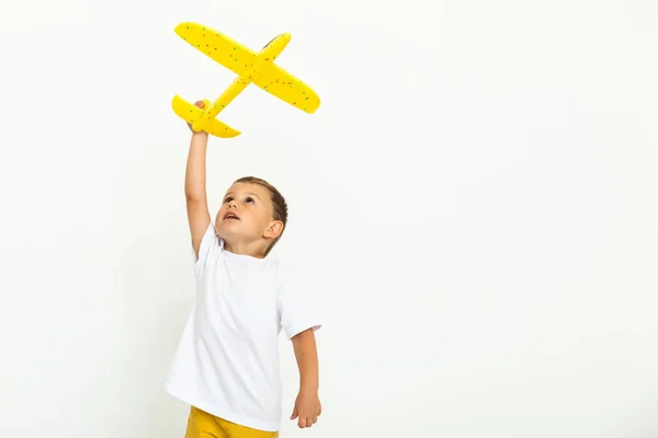 Niño feliz niño jugando con el avión amarillo del juguete —  Fotos de Stock