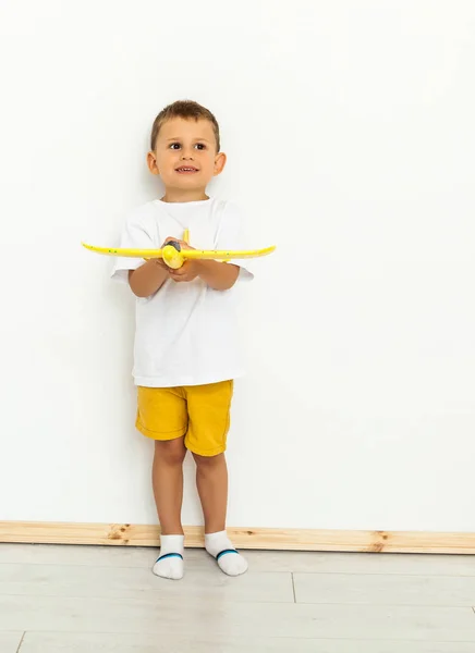 Gelukkige kind peuter spelen met gele speelgoed vliegtuig — Stockfoto