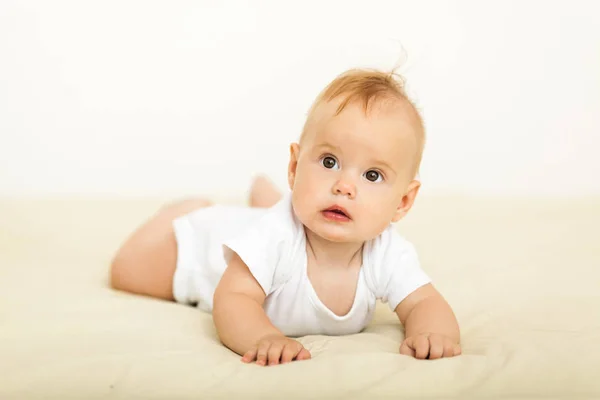 Portrait de sourire heureux bébé relaxant sur le lit — Photo