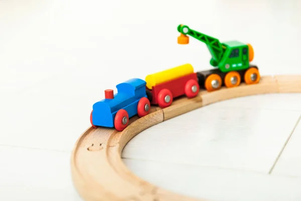 Kind met houten trein op de witte vloer — Stockfoto