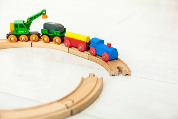 Kind met houten trein op de witte vloer — Stockfoto