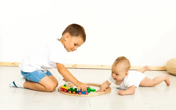 Симпатичные девочка и мальчик играют с игрушками у дома — стоковое фото