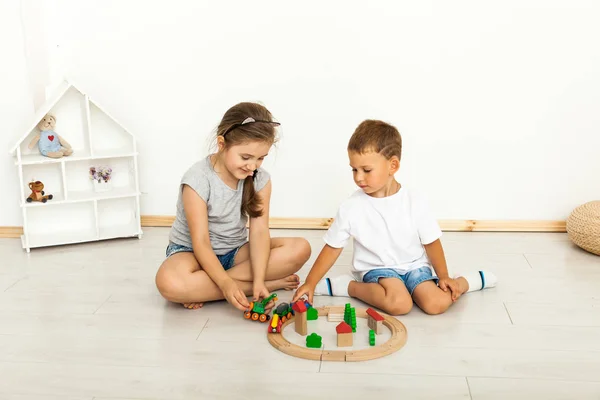 Linda niña y niño jugando con juguetes por la casa — Foto de Stock