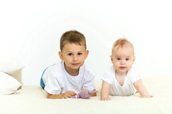 Portrait of brother and sister. Two cute children lying on bed — Stock Photo, Image