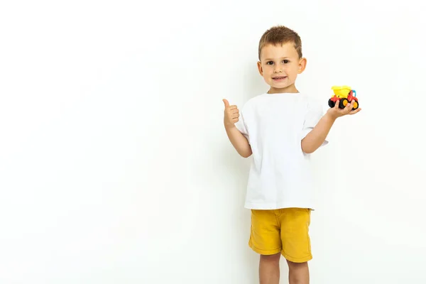 Retrato de un niño riéndose con el pulgar hacia arriba sobre fondo gris —  Fotos de Stock