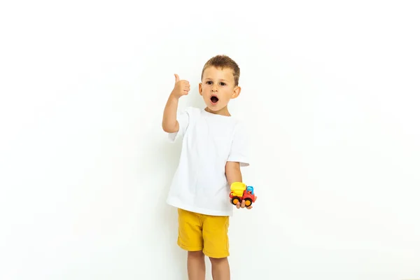 Retrato de un niño riéndose con el pulgar hacia arriba sobre fondo gris —  Fotos de Stock