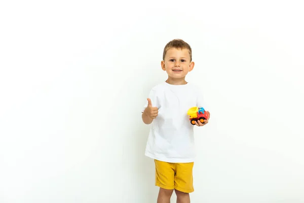 Retrato de un niño riéndose con el pulgar hacia arriba sobre fondo gris —  Fotos de Stock