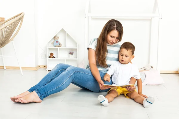 Madre sentada con hijo leyendo historia en interiores — Foto de Stock