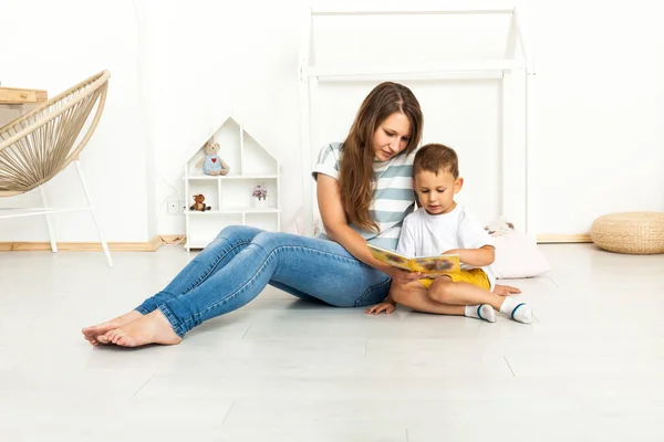 Madre sentada con hijo leyendo historia en interiores — Foto de Stock