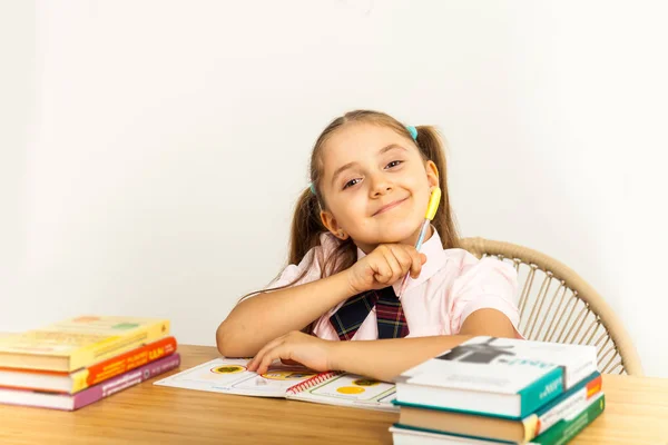 Meisje studeren aan tafel op witte achtergrond — Stockfoto