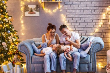 Güzel oturma odasında iki çocuklu Noel ailesi