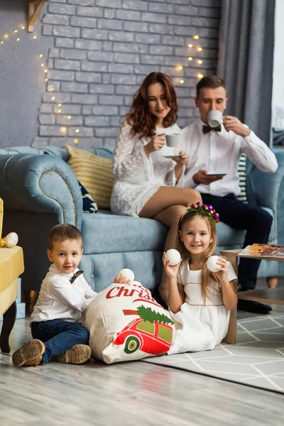 Happy Family Holding Christmas Gift Looking At Camera — Stock Photo, Image