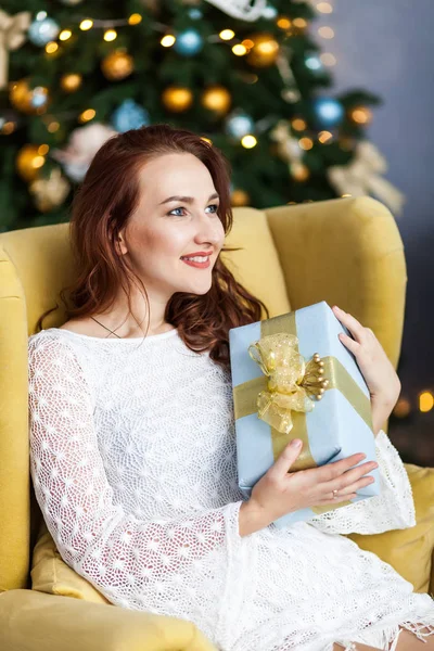 Portrait de jeune femme avec des boîtes cadeaux de Noël devant l'arbre de Noël — Photo