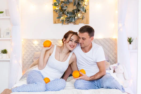 Couple of lovers in pajamas lying on the sofa. Christmas time. Holiday at home — Stock Photo, Image