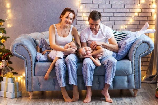 Güzel oturma odasında iki çocuklu Noel ailesi
