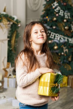 Noel ağacının önündeki hediye kutularıyla çocuk kız..