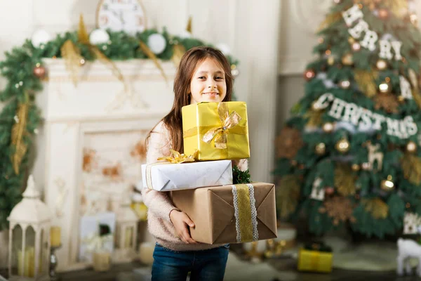 Barnepike foran juletreet med gavebokser . – stockfoto