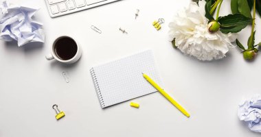 Banner, Beyaz Masa Masası. Not defteri, klavye, ofis malzemeleri, sarı kalem, buruşmuş kağıt toplar ve beyaz arka planda kahve fincanı ile çalışma hızı.