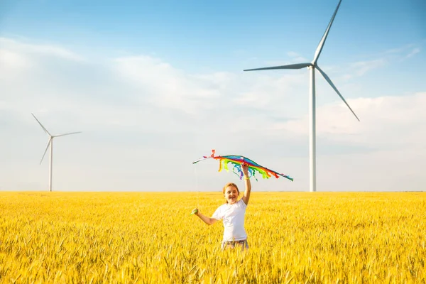 Happy Little girl running in a wheat field with a kite in the summer. Well-planned and active weekend. Happy childhood.