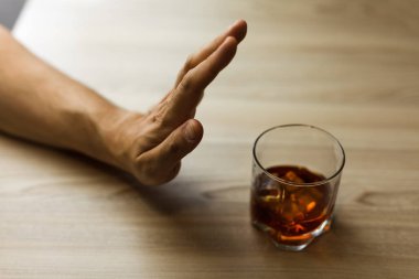 Eller içkiyi bırakmak için bir bardak viskiyi zincirliyor. Alkolizm konsepti. Alkol bağımlılığını durdur. Alkollü içeceğe bağımlı olmak.